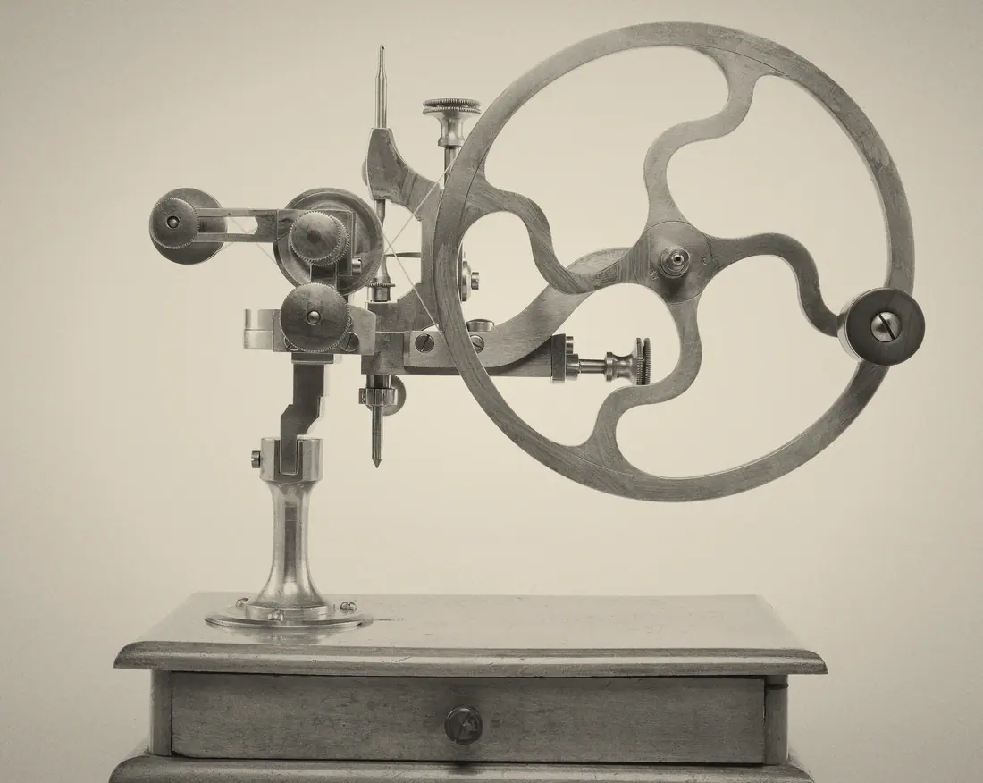 A brass wheel-cutting engine on its wooden base.