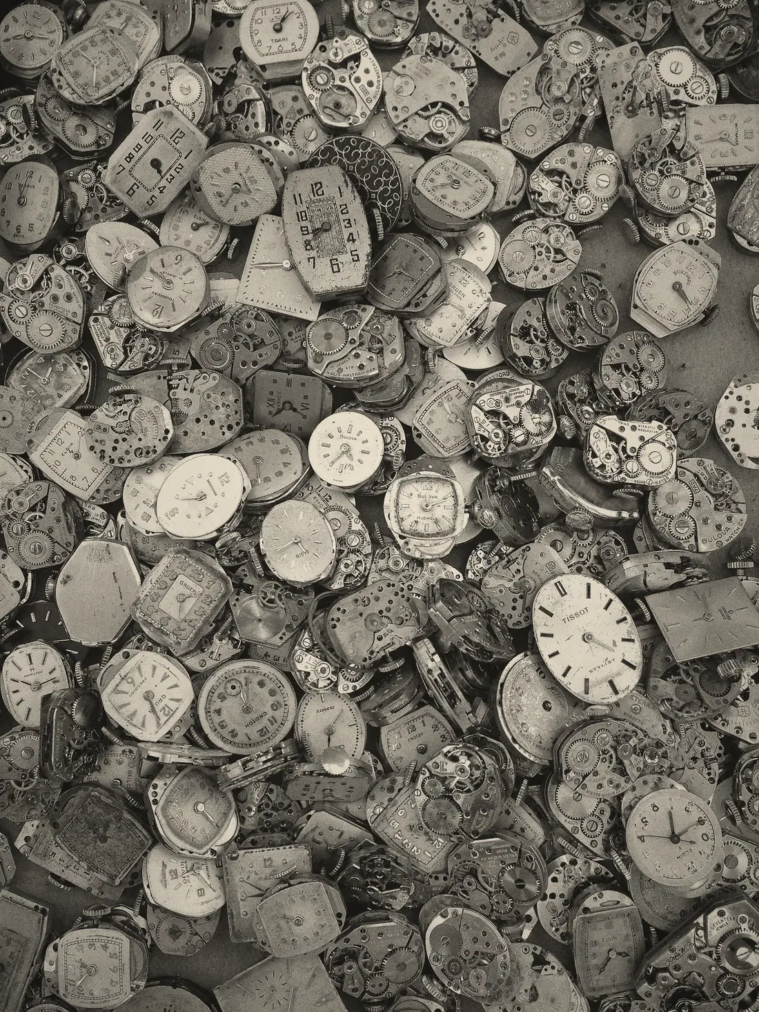 Hundreds of dismantled wristwatches gathered together.