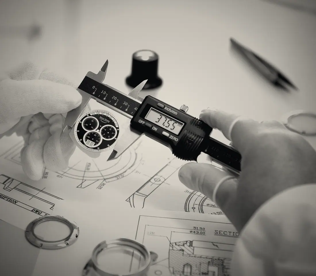 A component measured with calipers over a technical drawing.
